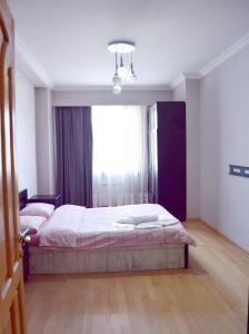 ein Schlafzimmer mit einem Bett und einem großen Fenster in der Unterkunft tbilisi tower 3 in Tbilisi City