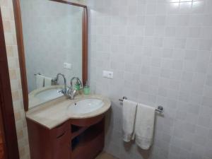 łazienka z umywalką i lustrem w obiekcie Apartamento La Real w mieście Caldas de Reis