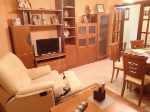 salon z białymi meblami i telewizorem w obiekcie Apartamento La Real w mieście Caldas de Reis