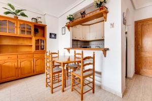 eine Küche mit Holzschränken, einem Holztisch und Stühlen in der Unterkunft Apartamento Parquemar V in La Mata