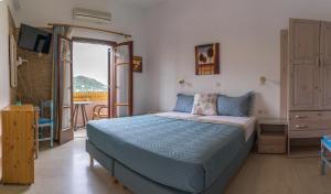 a bedroom with a large bed and a balcony at Eleni Goumenaki Plakias Studios in Plakias