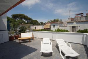 twee witte stoelen en een tafel op een patio bij suite in villa ad Ischia in Ischia
