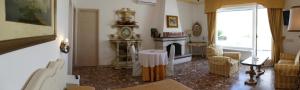 a living room with a fireplace and a clock in a room at Appartamento in villa ad Ischia in Ischia