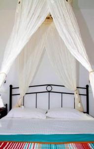 a bed with a canopy with white mosquito nets at Anemoessa Studios in Serifos Chora
