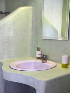 a bathroom with a pink sink and a mirror at Anemoessa Studios in Serifos Chora