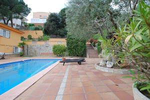 ein Pool mit einer Bank neben einem Haus in der Unterkunft Villa Magnolia in Mataró