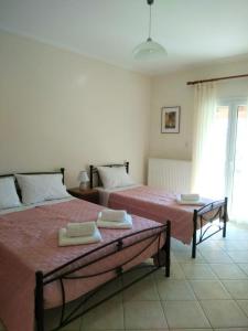 a bedroom with two beds with towels on them at Lonelia's Family Homes in Lefkímmi