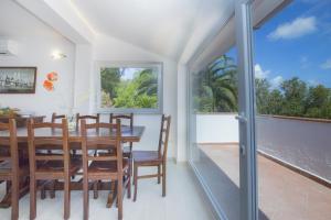 a dining room with a table and chairs and a balcony at Villa Mara - Goelba in Capoliveri