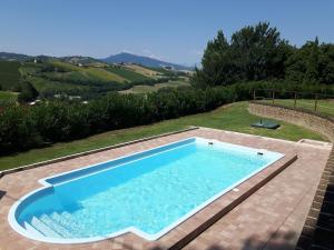 a swimming pool with a view of the hills at La Casa in Campagna in Cossignano