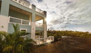 um edifício branco com o sol no céu em Island Charm Culebra Studios & Suites - Amazing Water views from all 3 apartments located in Culebra Puerto Rico! em Culebra