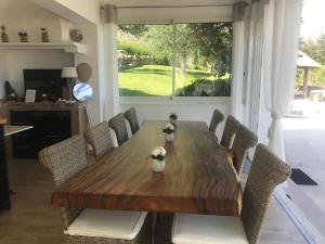 uma mesa de jantar com cadeiras e uma grande janela em Villa Kilauea B&B em Nice