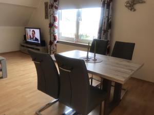 uma sala de jantar com uma mesa de madeira e cadeiras em Haus Pop em Borkum