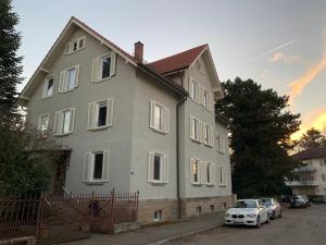 a large house with cars parked in front of it at Deluxe Business City Apartments Metzingen Villa Landenberger in Metzingen