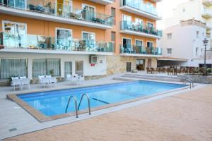 un apartamento con piscina frente a un edificio en Hotel Costa Mediterraneo en El Arenal