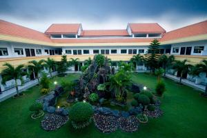 a large building with a garden in front of it at Hotel Sinar 2 in Sedati