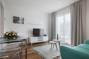 a living room with a glass table and a tv at Tendency Rambla del Poblenou in Barcelona