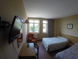 Habitación de hotel con 2 camas y TV de pantalla plana. en Dunas de Oyambre, en Comillas