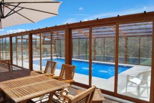 um pátio com uma mesa e cadeiras e uma piscina em CASA RURAL EL PILON em Torre Val de San Pedro