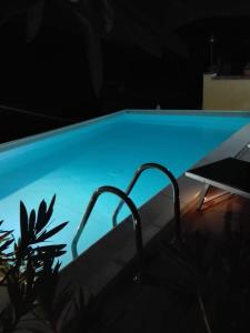 a blue swimming pool at night with a table at B&B Il Belvedere in Guardialfiera