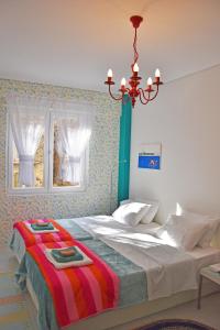 een slaapkamer met een groot bed met een kroonluchter bij Short Stay Studio in Thessaloniki