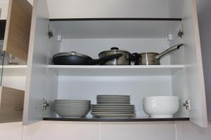 a cupboard with dishes and pots and pans at City center apartment in Liepāja