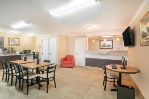 a dining room with two tables and a kitchen at Travelodge by Wyndham Santee in Santee