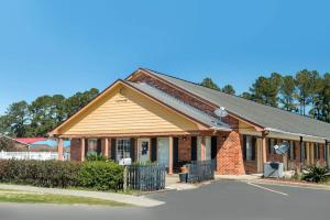 a small house with a brick building at Travelodge by Wyndham Santee in Santee