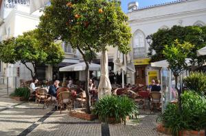 un café en plein air avec des tables et des parasols dans l'établissement Apartment Lindamar, à Lagos
