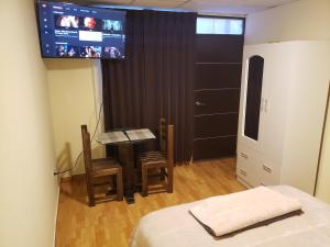 1 dormitorio con mesa y TV en la pared en CASA DE TURISTAS AREQUIPA en Arequipa
