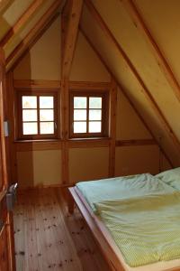 a bedroom with a bed and two windows at FH Strowota in Kolonie
