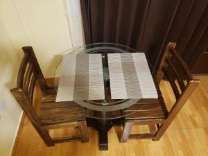 a glass table with two chairs with a book on it at CASA DE TURISTAS AREQUIPA in Arequipa
