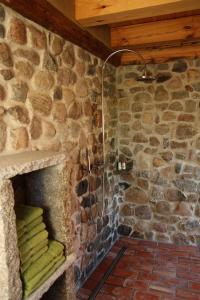 um chuveiro de pedra na casa de banho com uma parede de pedra em FH Strowota em Kolonie