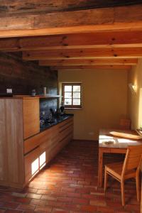uma cozinha com armários de madeira e uma mesa num quarto em FH Strowota em Kolonie