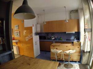 uma cozinha com armários de madeira e uma mesa de madeira em Sardines and Friends Hostel 04 na Póvoa do Varzim