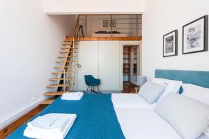 een slaapkamer met een bed met een blauwe deken bij FLH Alfama River View Flat in Lissabon
