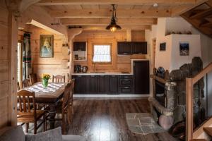 eine Küche und ein Esszimmer mit einem Tisch in einer Hütte in der Unterkunft Domki i Apartamenty Na Wyskówkach Jacuzzi & Sauna in Zakopane