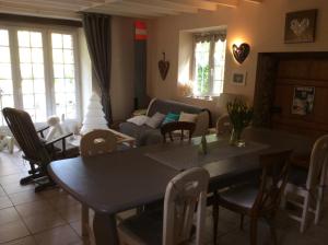 a living room with a table and chairs and a couch at Le moulin de la Castellerie in Moon-sur-Elle