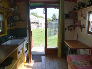 een keuken met een deur naar een tuin bij Roulotte coin de nature in Lannion