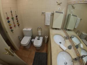 a bathroom with a sink and a toilet and a shower at Golf & Beach Apartment in Charneca +17 photos