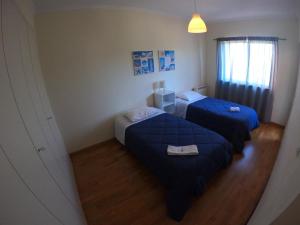 a bedroom with two beds and a window at Golf & Beach Apartment in Charneca