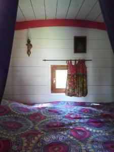 a bed in a room with a window at Roulotte coin de nature in Lannion