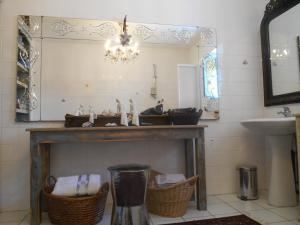 un camino in bagno con specchio e lavandino di Le vieux Prieuré a Cressé