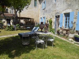 een tafel en stoelen in de tuin van een huis bij Le vieux Prieuré in Cressé
