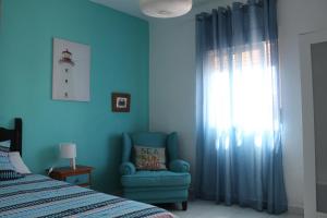 アヤモンテにあるAloja Puerto Deportivoのベッドルーム1室(ベッド1台、椅子、窓付)