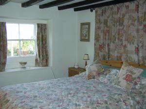 a bedroom with a bed and a window at Pat's Cottage in Sheffield