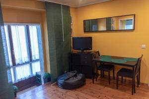 a dining room with a table and a television at Apartamentos San Roque in Llanes