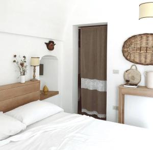 1 dormitorio con cama blanca y ventana en Masseria Fenicia, en Monopoli