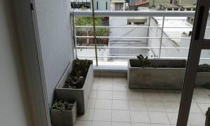 un balcón con 2 macetas de plantas en una ventana en Cómodo Departamento en el Centro en Buenos Aires