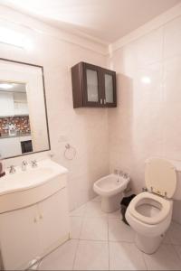 biała łazienka z toaletą i umywalką w obiekcie Cómodo Departamento en el Centro w BuenosAires