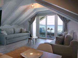 uma sala de estar com um sofá e vista para o oceano em Anemoessa Elegant Apartments em Skala Potamias